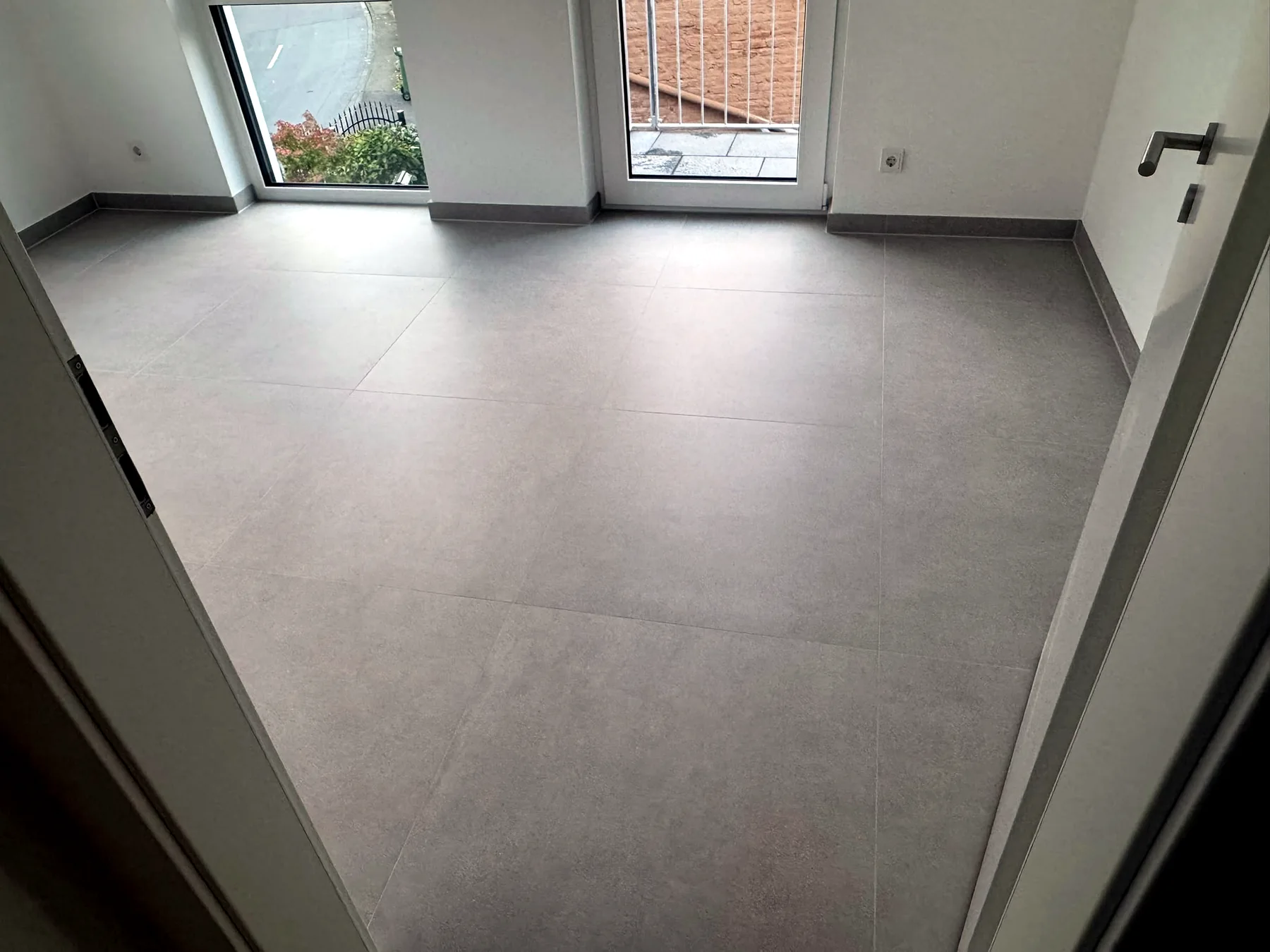 Fertig verlegte Großformatfliesen in einem hellen Wohnraum